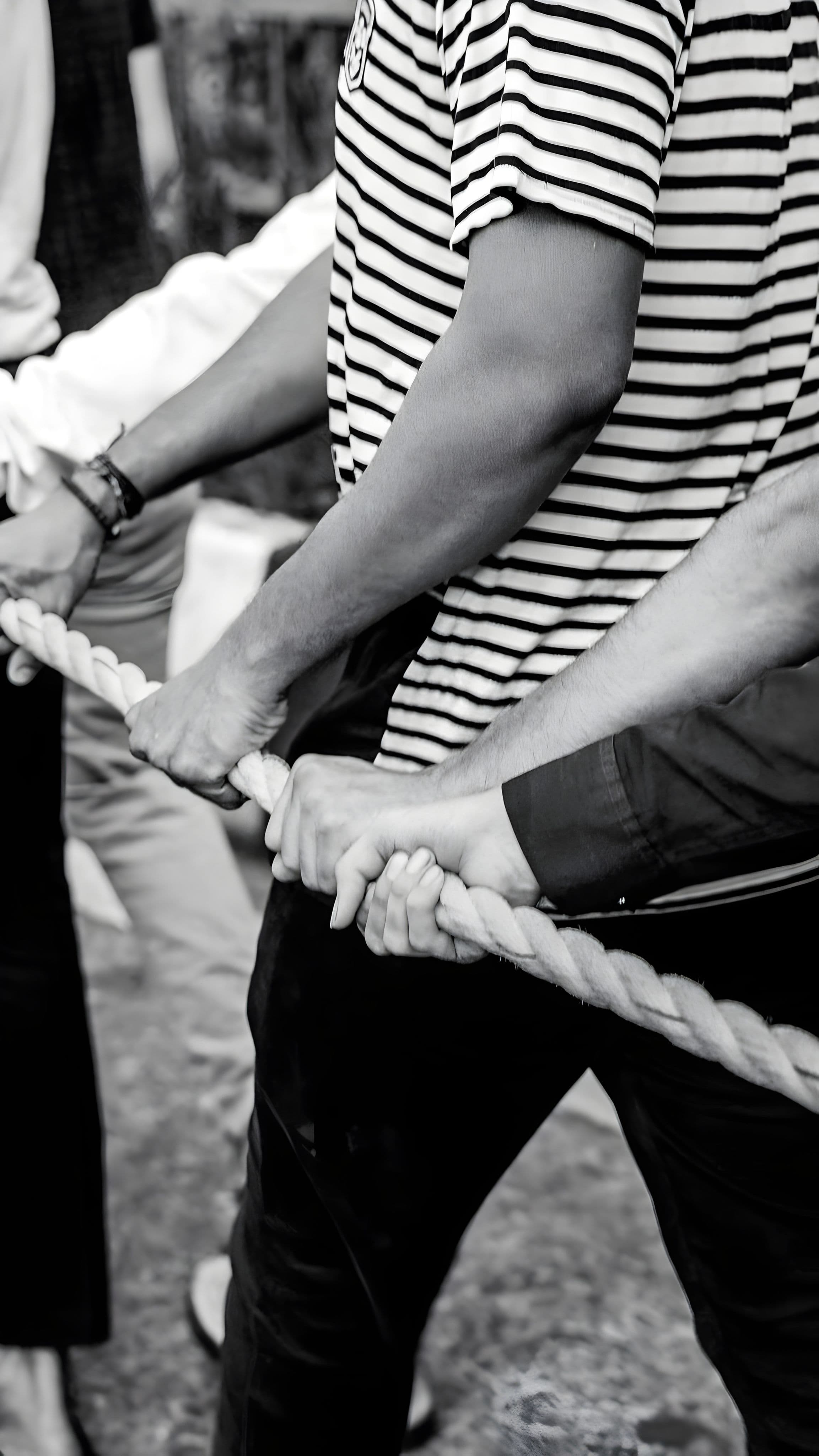 Hands pulling together on one rope