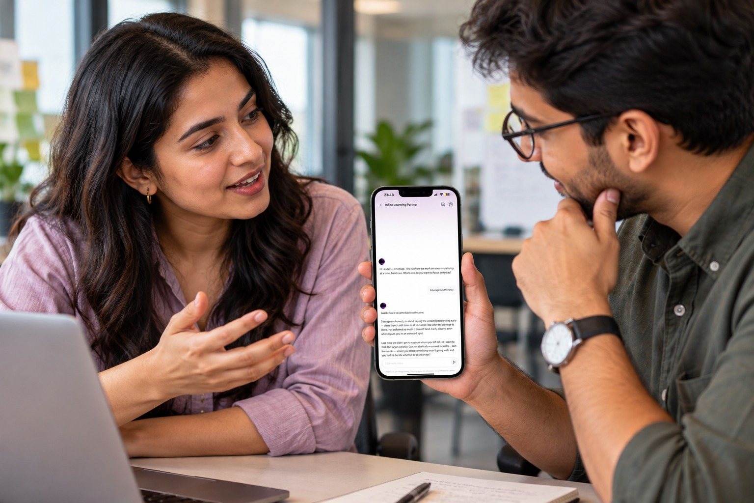 A leader holding a phone showing the Invincible YOU app’s BRIDGE Journey — a timeline of completed labs and assessments